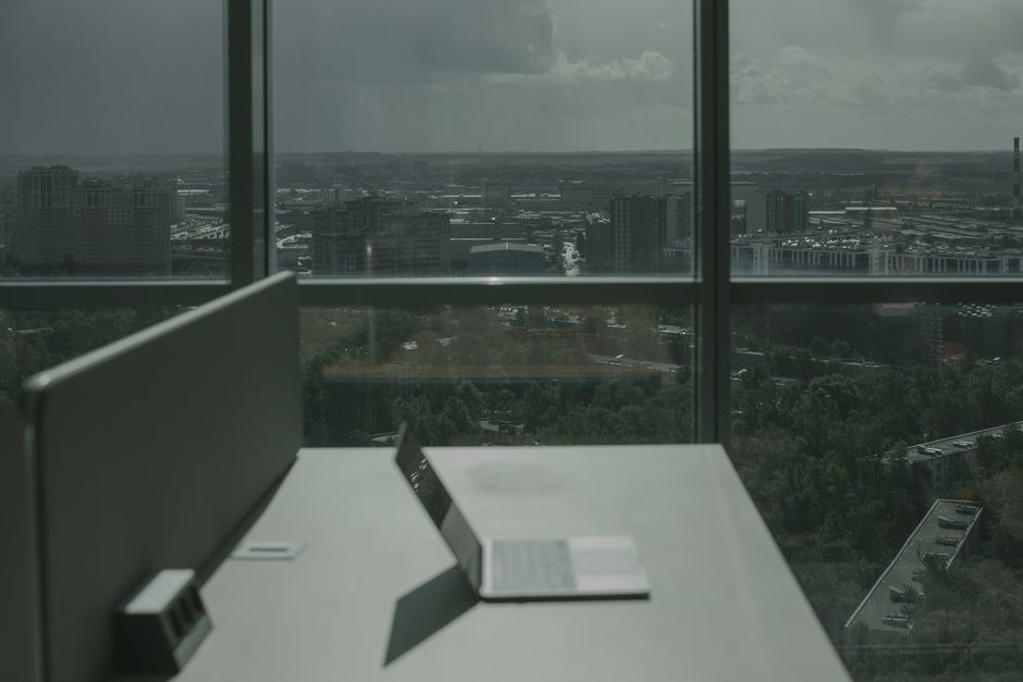 Laptop en escritorio de oficina con vista al horizonte de la ciudad