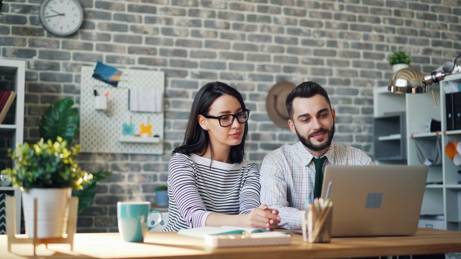 Dos jóvenes profesionales trabajando en equipo